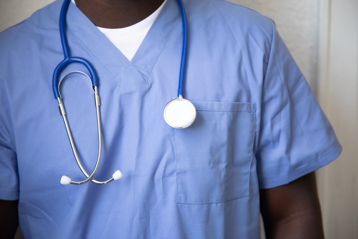 Profissional de saúde vestindo scrub azul com estetoscópio